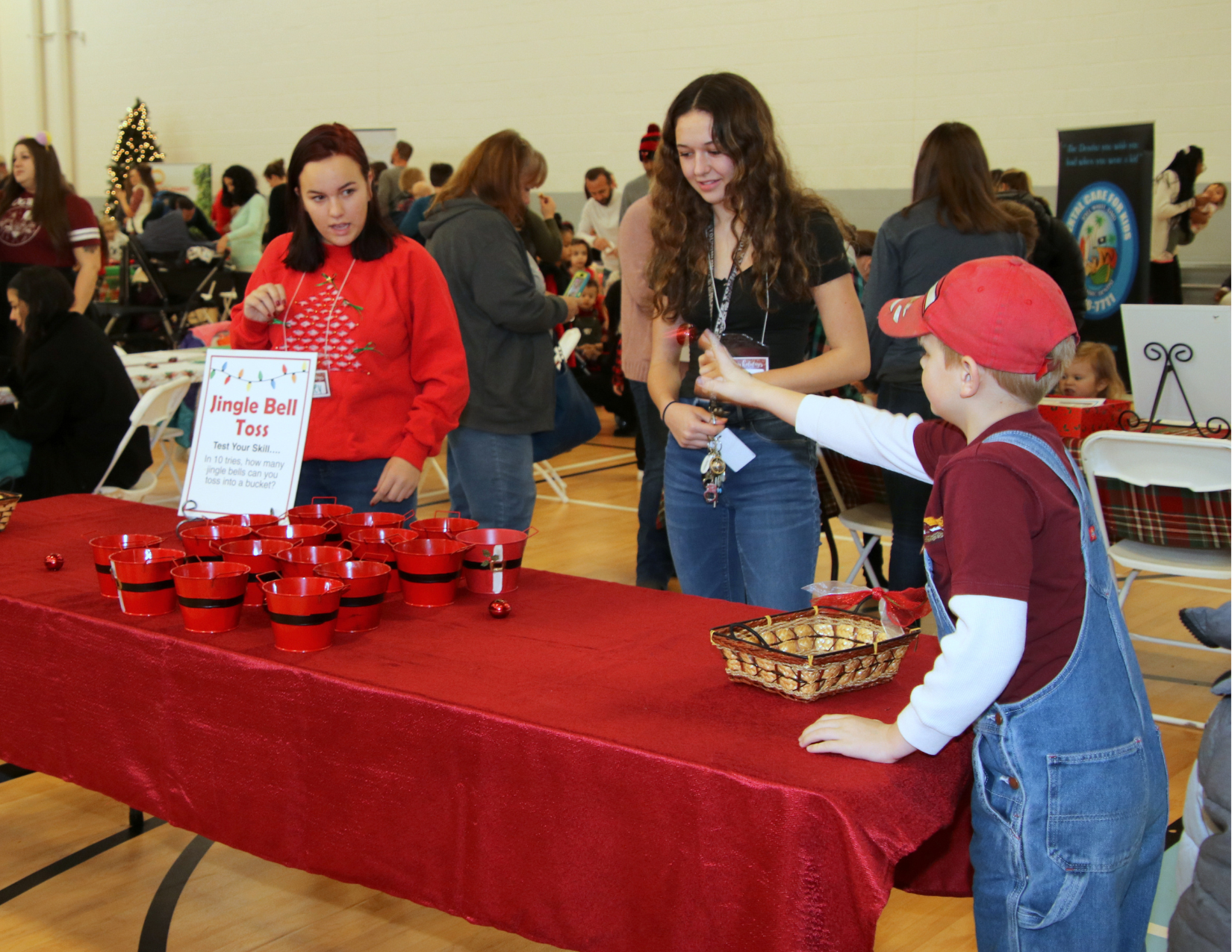 Volunteers helping a young person with a game at an indoor Christmas event